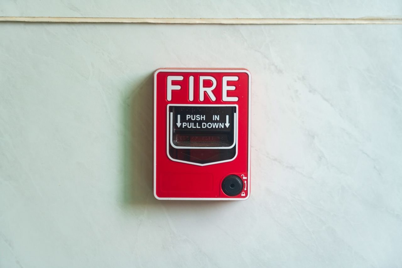 Home Image of a wall mounted red fire alarm device for safety alerts and emergency preparedness.